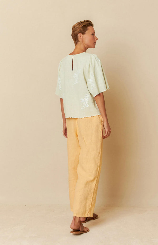 camisa abrochada atras con bordados y ribete en onda